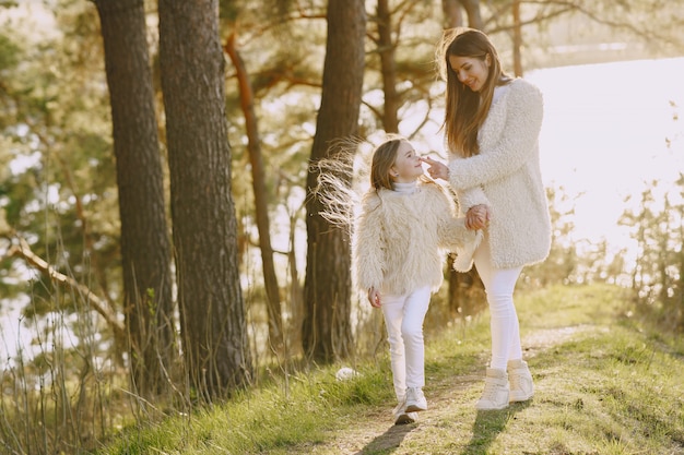 Elegante madre con hija en un bosque de verano