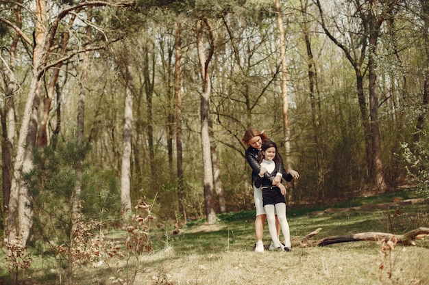 Elegante madre con hija en un bosque de verano