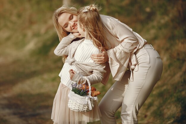 Elegante madre con hija en un bosque de verano