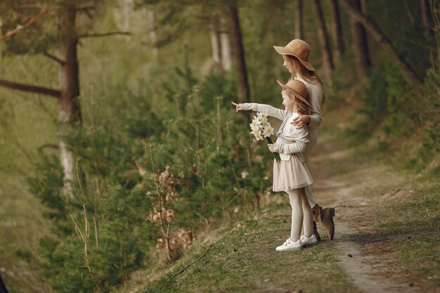 Elegante madre con hija en un bosque de verano