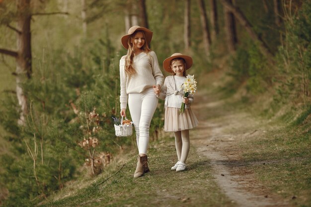 Elegante madre con hija en un bosque de verano