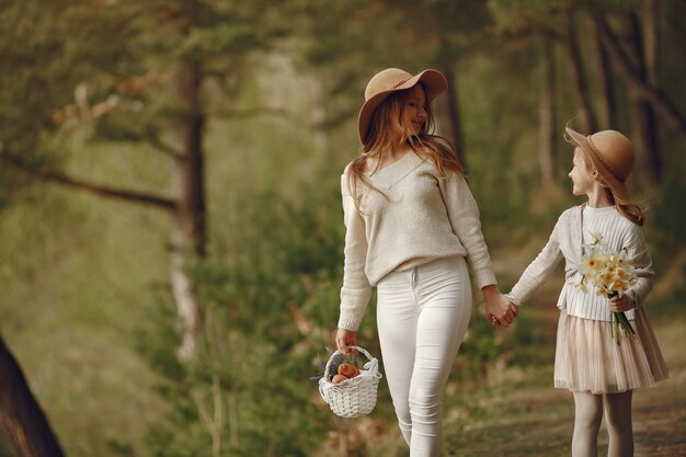 Elegante madre con hija en un bosque de verano