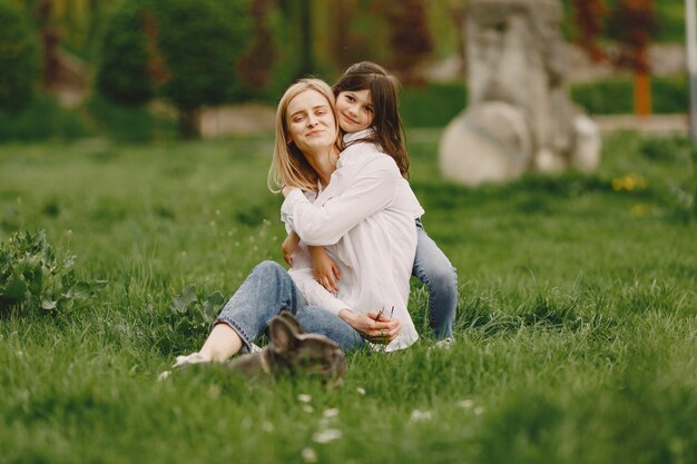 Elegante madre con hija en un bosque de verano