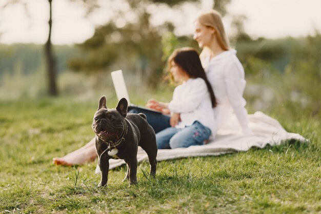 Elegante madre con hija en un bosque de verano