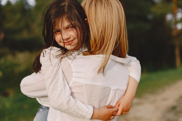 Elegante madre con hija en un bosque de verano