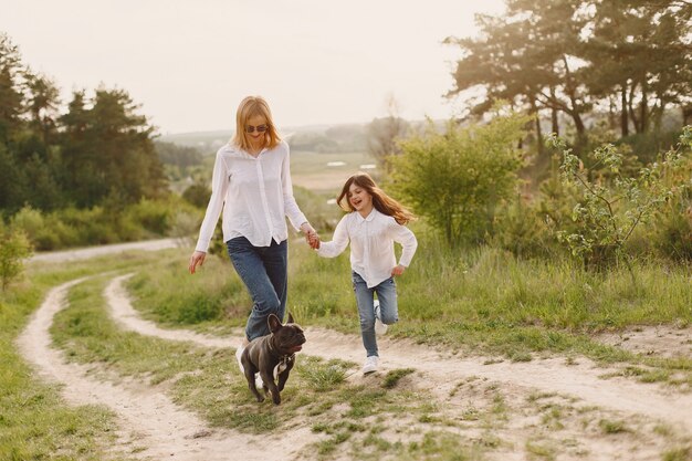 Elegante madre con hija en un bosque de verano