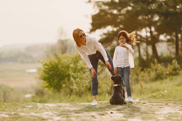 Elegante madre con hija en un bosque de verano