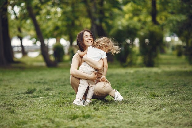 Elegante madre con hija en un bosque de verano