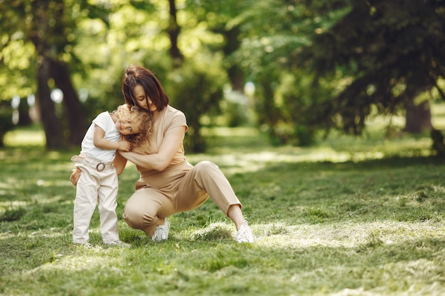 Elegante madre con hija en un bosque de verano