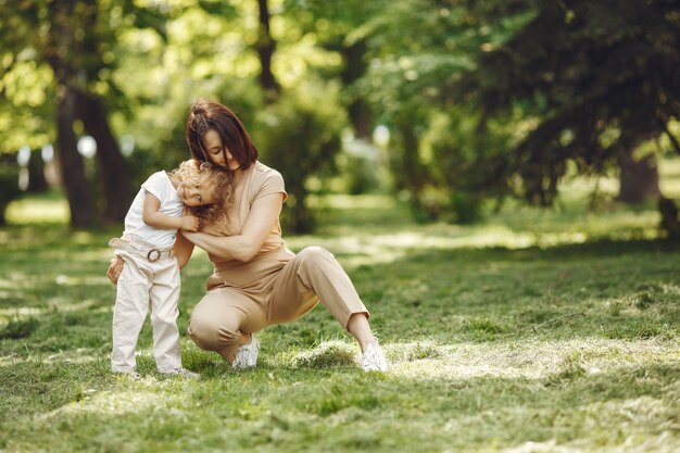 Elegante madre con hija en un bosque de verano