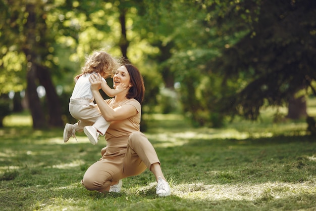 Elegante madre con hija en un bosque de verano