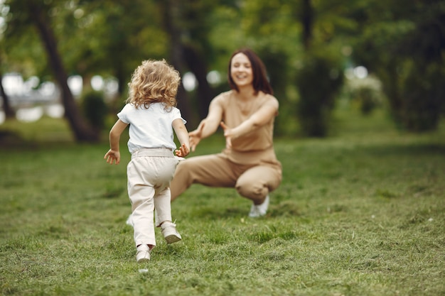 Elegante madre con hija en un bosque de verano