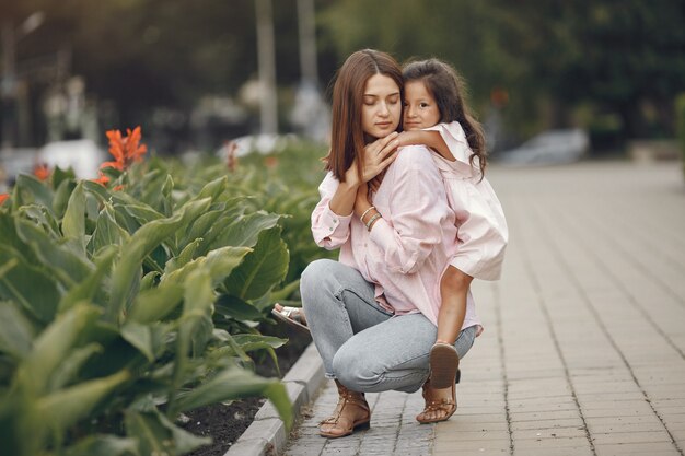 Elegante madre con hija en un parque de verano