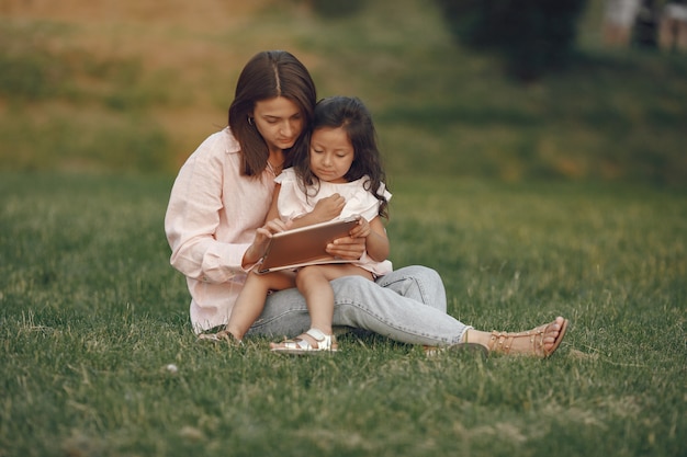 Elegante madre con hija en un parque de verano