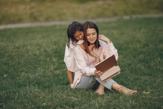 Elegante madre con hija en un parque de verano