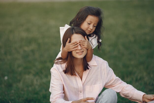 Elegante madre con hija en un parque de verano