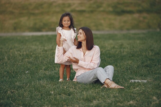 Elegante madre con hija en un parque de verano