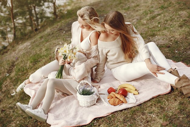 Elegante madre con hijos en un bosque de verano