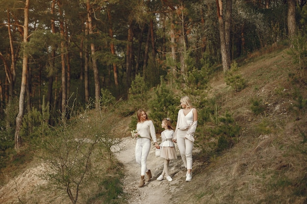 Elegante madre con hijos en un bosque de verano