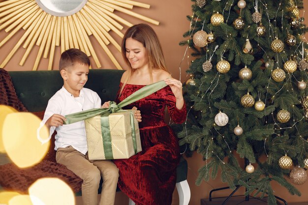 Elegante madre sentada en casa con pequeño hijo