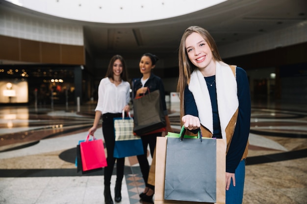 Elegante modelo con amigos en el centro comercial