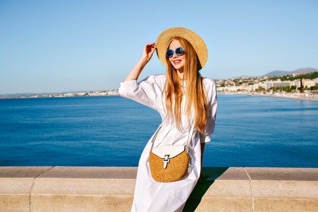 Elegante modelo bastante rubia posando en el punto de vista de Niza Francia, vistiendo elegante traje de verano