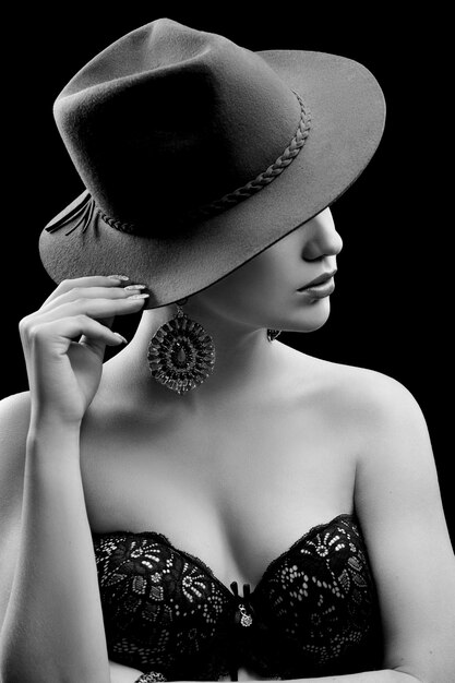 Elegante modelo femenino con un sombrero ocultando su rostro