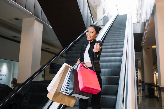 Elegante modelo gesticulando en la cámara con bolsas