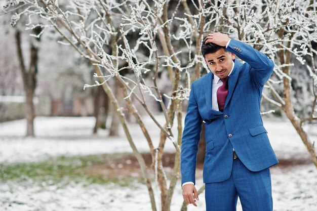 Elegante modelo de hombre de moda indio en traje posado en el día de invierno