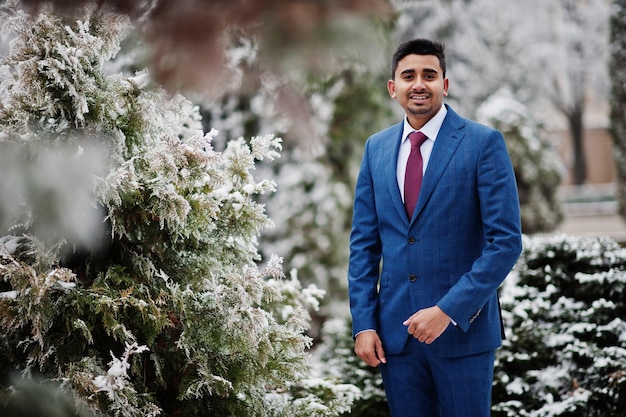 Elegante modelo de hombre de moda indio en traje posado en el día de invierno