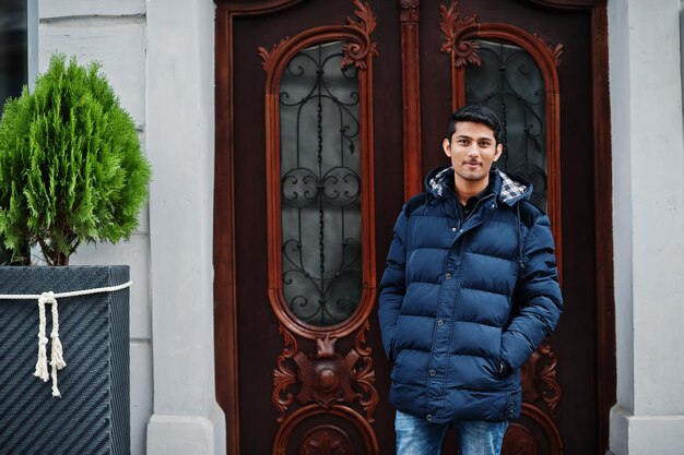 Elegante modelo indio hombre con chaqueta posado al aire libre en la calle de la India