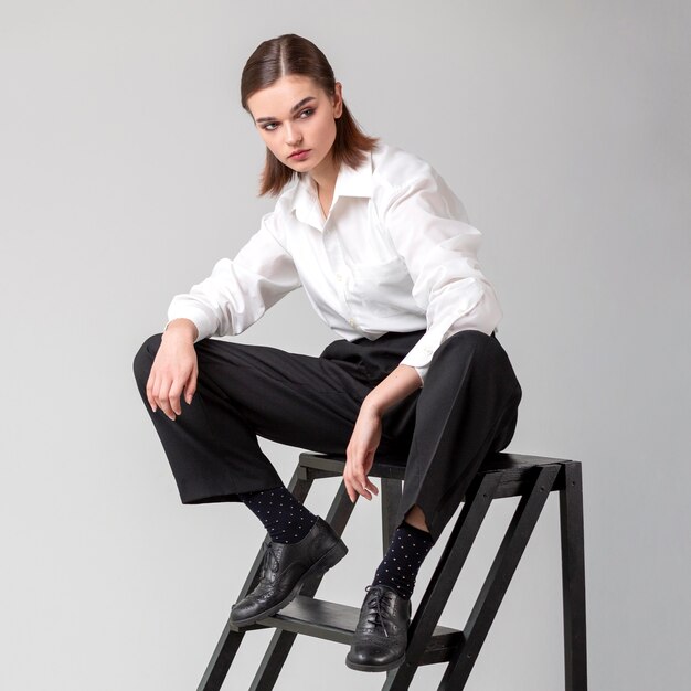 Elegante modelo de mujer posando en las escaleras con un traje de chaqueta. nuevo concepto de feminidad