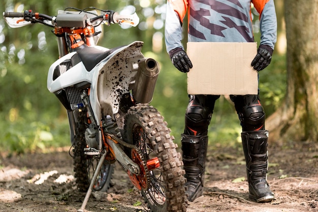 Foto gratuita elegante motociclista con cartel de cartón