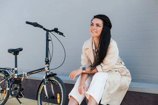 Foto gratuita elegante mujer adulta posando con bicicleta ecológica