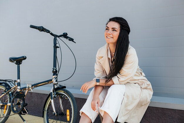 Elegante mujer adulta posando con bicicleta ecológica