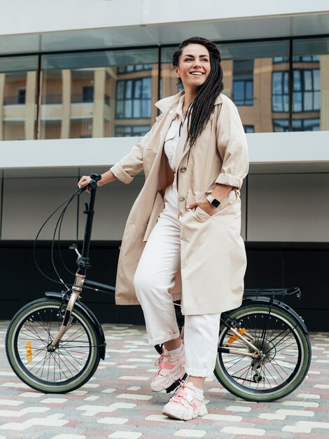 Elegante mujer adulta posando con bicicleta ecológica