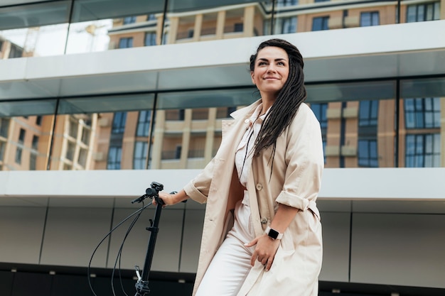 Elegante mujer adulta posando con bicicleta ecológica