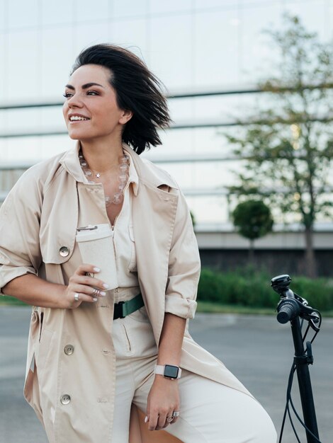 Elegante mujer adulta posando con bicicleta ecológica