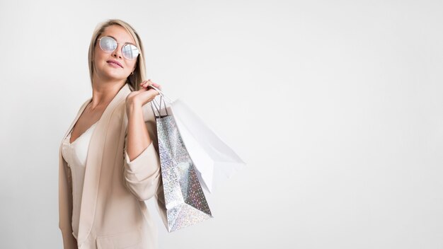 Elegante mujer adulta posando con bolsa de compras