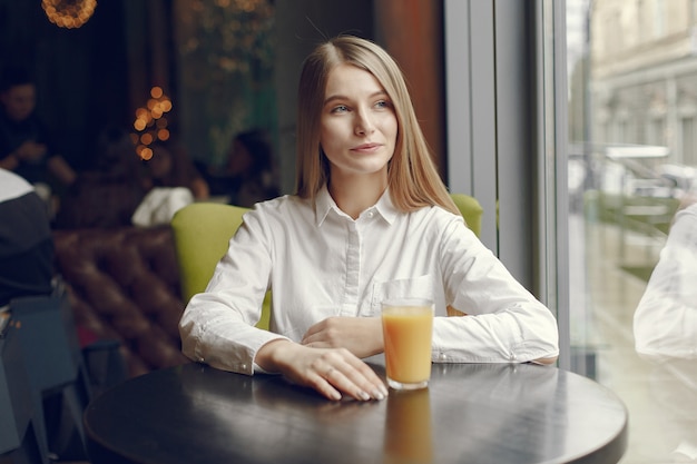 Elegante mujer en una blusa blanca pasar tiempo en un café