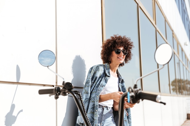 Foto gratuita elegante mujer bonita en gafas de sol mediante teléfono móvil