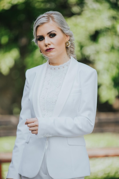 Elegante mujer caucásica de moda con un bonito traje blanco y pantalones posando para una sesión de fotos de moda