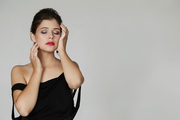 Elegante mujer encantadora posando con vestido negro