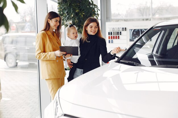 Elegante mujer con hija pequeña en un salón del automóvil