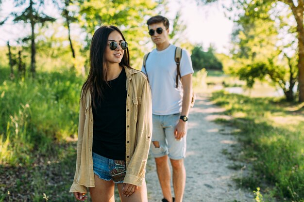 Elegante mujer joven de pie delante de excursionista masculino