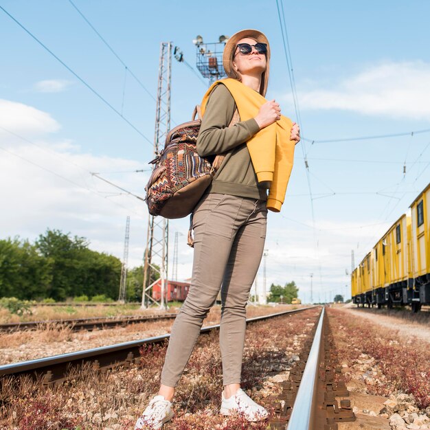 Elegante mujer joven con sombrero y mochila