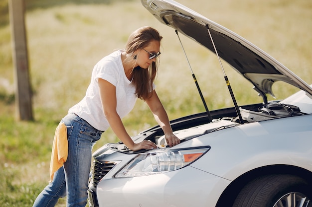 Elegante mujer limpia el auto con un trapo