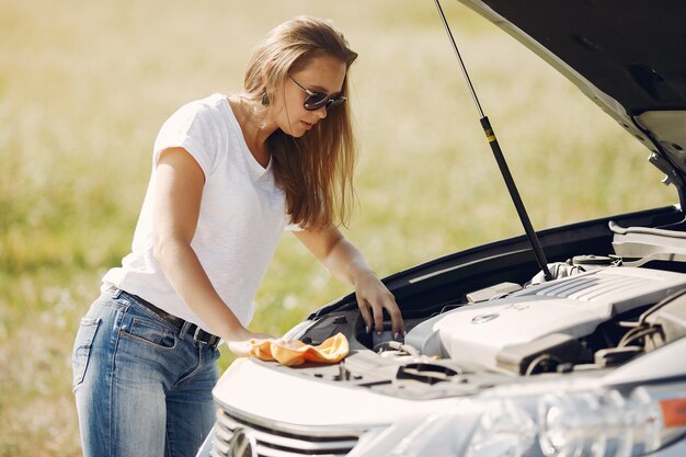 Elegante mujer limpia el auto con un trapo