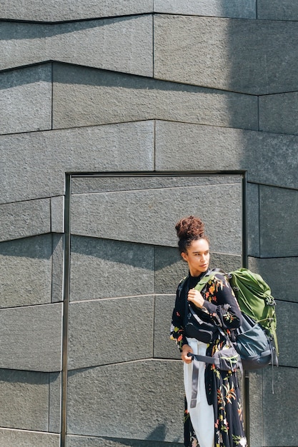 Foto gratuita elegante mujer llevando mochila mirando al aire libre