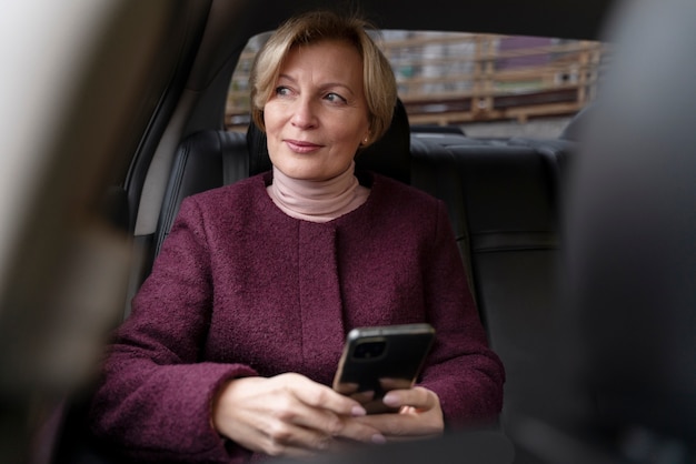 Elegante mujer madura sentada en un taxi